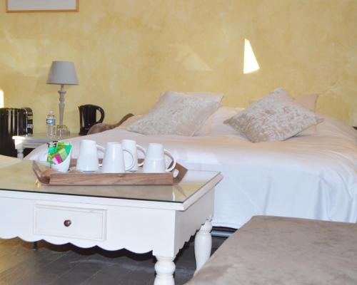 a white bed with a tray of cups on it at Le Clos Margot in Vertus