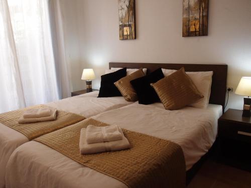 1 dormitorio con 1 cama grande y 2 toallas. en Tranquil apartment close to pool, en Águilas