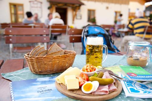 uma mesa com um prato de comida e um copo de cerveja em Hofstub´n em Eschlkam