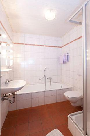 a bathroom with a tub and a sink and a toilet at Hofstub´n in Eschlkam