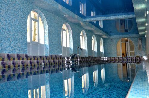 una piscina con paredes y ventanas azules y agua en Perlyna Podillyа, en Sataniv