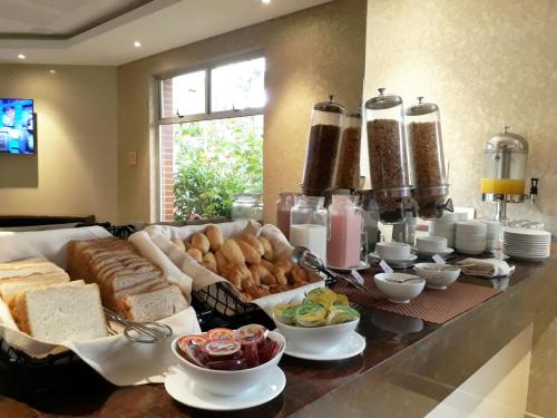 a breakfast buffet with bread and other foods on a counter at Hotel Plaza Suites in Bogotá