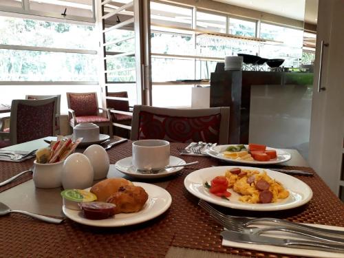 a table with plates of food on top of it at Hotel Plaza Suites in Bogotá