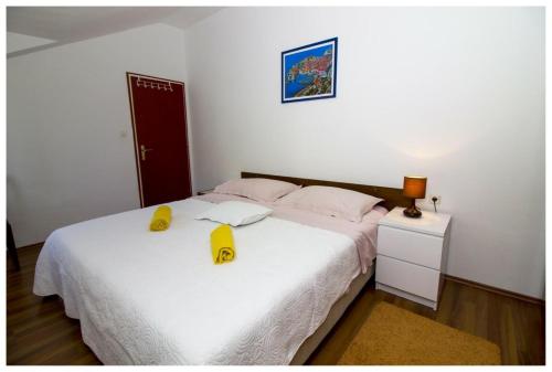 a bedroom with a bed with two yellow hats on it at Apartment Mona Lisa in Mokošica