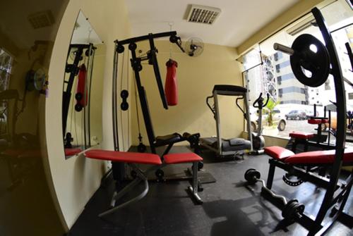 un gimnasio con varias bicicletas estáticas y un espejo en King Konfort Hotel, en Maringá