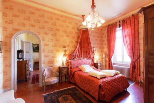 une chambre avec un lit et un lustre dans l'établissement Château des Fontaines, à Canet d'Aude
