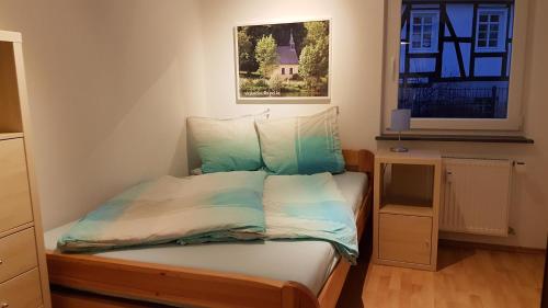 a small bedroom with a bed and a window at Köster Apartment in Olpe