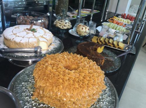 a buffet of different types of cakes and pastries at King Konfort Hotel in Maringá