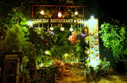 塞尔丘克西林千旅馆的一个花园，上面挂着一块牌子，写着“花园餐厅和咖啡馆”。