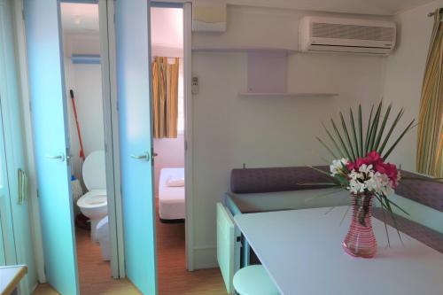 a bathroom with a white counter with a vase of flowers at Centro Vacacional Macenas in Mojácar