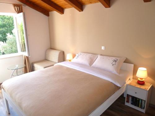 a bedroom with a large white bed and a window at Nice Apartment & Room in Cavtat in Cavtat