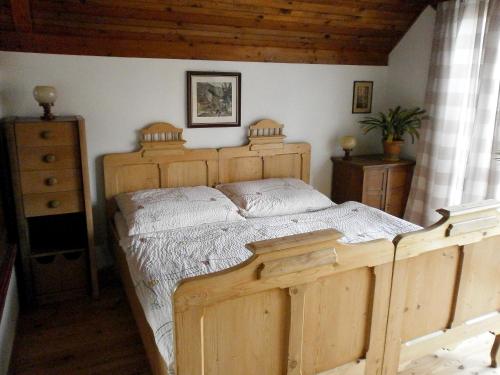 a bedroom with a wooden bed and a dresser at Letni byt in Povrly