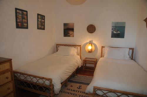 ポルト・サントにあるCharming Villa at the beachのベッドルーム1室(ベッド2台付)、壁にランプが備わります。