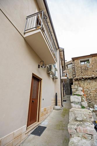 an alley with a door and a balcony on a building at B&B Acquachiara in Roccella Ionica