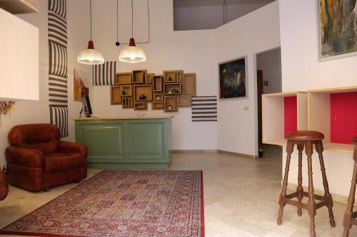 a living room with a table and a chair and a rug at Dimora Hostel in Agrigento