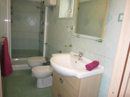 uma casa de banho com um lavatório, um WC e um espelho. em L'ANGOLO DEI ROMANTICI em Ponza