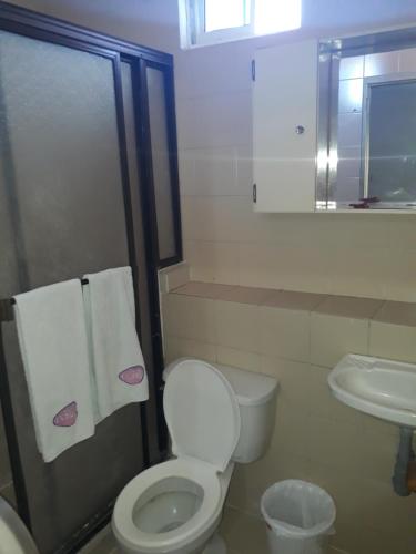 bagno con servizi igienici e lavandino con asciugamani di Hotel Colonial Inn a Barranquilla