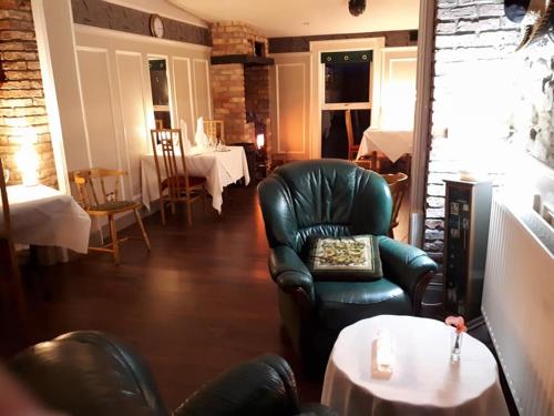 un soggiorno con tavolo e sedia in pelle di Ardgort Country House a Castlederg