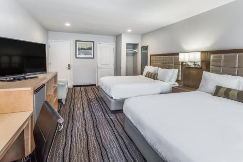 バークレーにあるバークレー トラベロッジのベッド2台、薄型テレビが備わるホテルルームです。