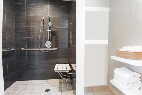 Łazienka z prysznicem wyłożona jest czarnymi kafelkami. w obiekcie Sather Berkeley - SureStay Collection by Best Western w mieście Berkeley