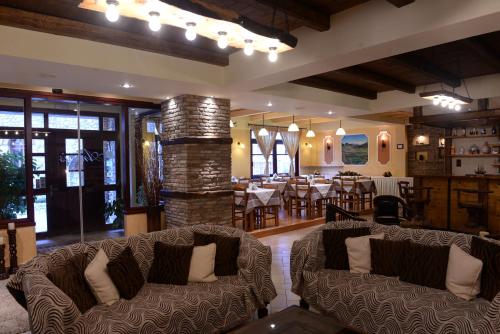 a living room with two couches and a dining room at Anesis Hotel in Kalavrita