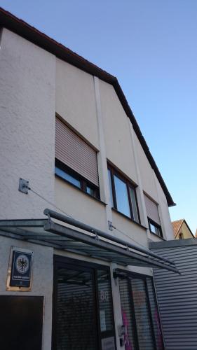 a white building with windows and a sign on it at Gästehaus Langhammer in Bubenreuth