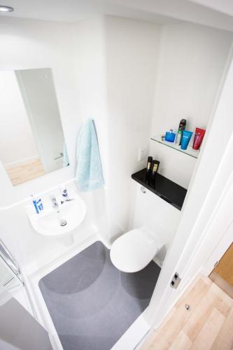 a white bathroom with a toilet and a sink at UHI Dornoch- Campus Accommodation in Dornoch