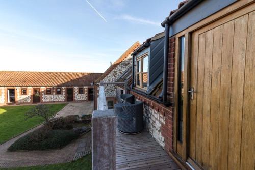 a deck with a wooden fence and a building at Briarfields Hotel in Titchwell