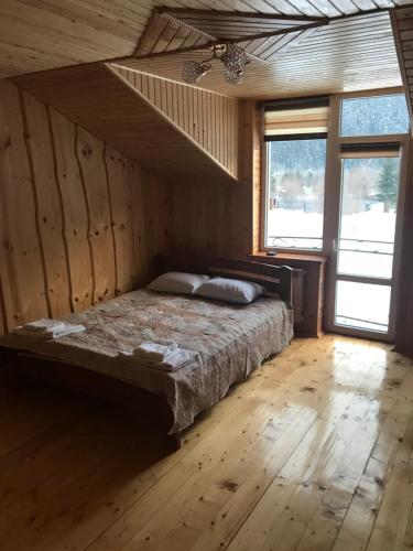 ein Schlafzimmer mit einem Bett in einem Zimmer mit Holzwänden in der Unterkunft mijgirya in Usteriki