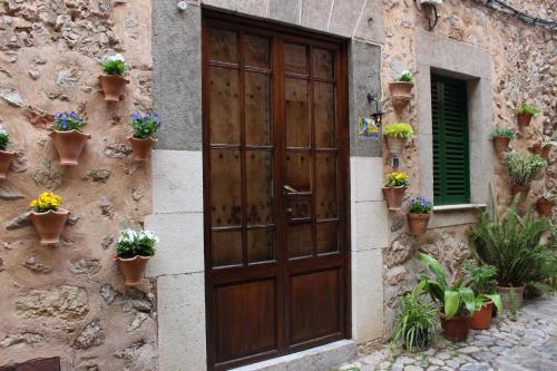 eine Holztür in einem Steingebäude mit Topfpflanzen in der Unterkunft Rectoria 6 in Valldemossa