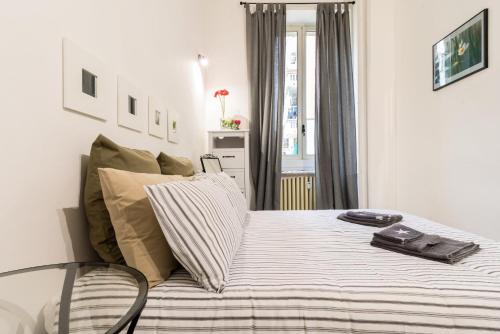ミラノにあるCasa Tibaldi - Bocconiのベッドルーム1室(ストライプ毛布付きのベッド1台付)