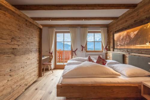 a bedroom with two beds and a wooden wall at Egarterhof in San Candido