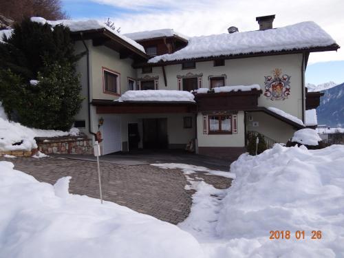 a house with a pile of snow in front of it at Gästehaus Walch-Riml in Imst