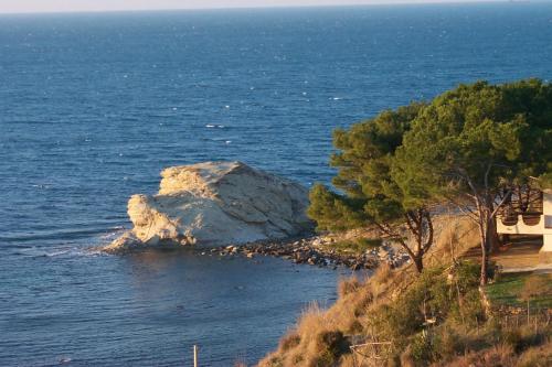 a large rock in the water next to a beach at Casa Le Querce in Ogliastro Cilento
