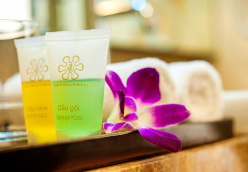 a purple flower sitting next to two cups of sunscreen at Garco Dragon Hotel in Hanoi