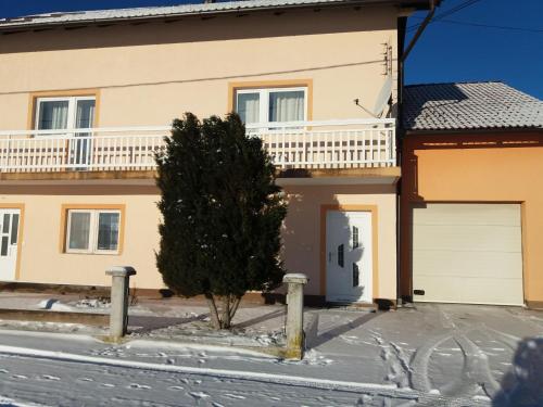 a house with a tree in front of it at Ljudina in Kupres