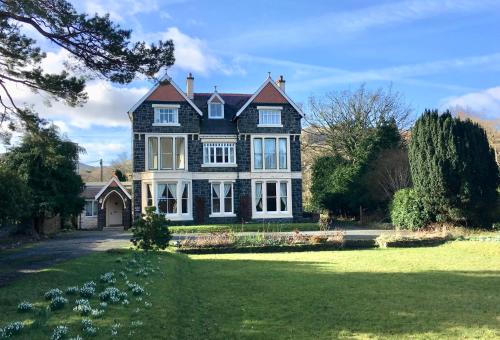 a large black and white house with a yard at Dolafon Guest House in Llanberis