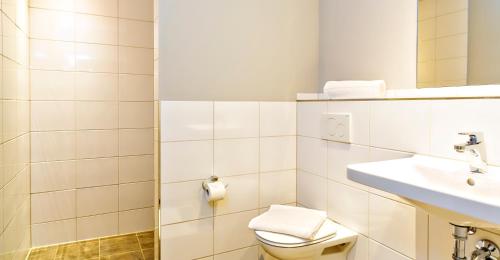 a white bathroom with a toilet and a sink at das MAX Appartementhaus in Bad Wörishofen