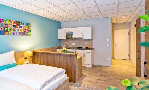 a bedroom with a bed and a kitchen at das MAX Appartementhaus in Bad Wörishofen