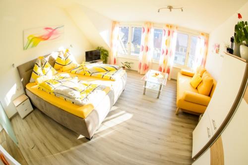 a bedroom with two beds and a yellow chair at Gästehaus Haiminger ehemalig Schmelz in Weissenkirchen in der Wachau