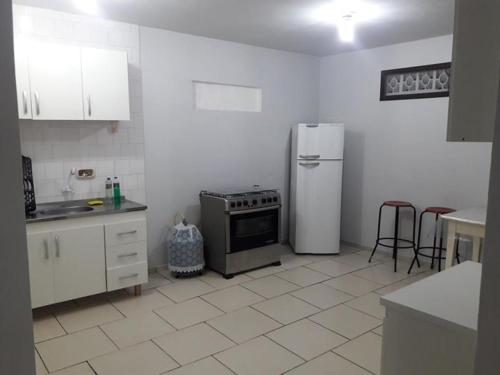 eine Küche mit Kühlschrank und Herd in der Unterkunft Casa na Praia - Uma quadra do mar in Itapoa