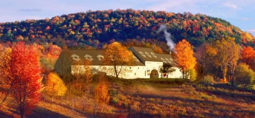 a barn in the middle of a hill with trees at The Inn at Cooperstown in Cooperstown