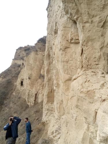 two people standing next to a rocky mountain at My home udabno in Udabno