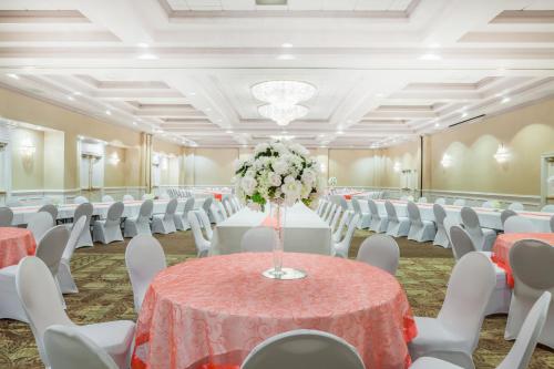 a banquet hall with tables and chairs and a vase of flowers at Wyndham Virginia Beach Oceanfront in Virginia Beach