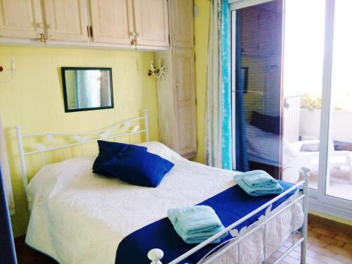 une chambre avec un lit avec des oreillers bleus dessus dans l'établissement Les Emeraudes, à La Croix-Valmer