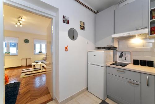 a kitchen with white appliances and a living room at Block Apartment Upper Town in Zagreb