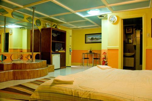 فندق ومطعم كوكوموس في انجلس: غرفة نوم بسرير كبير ومطبخ