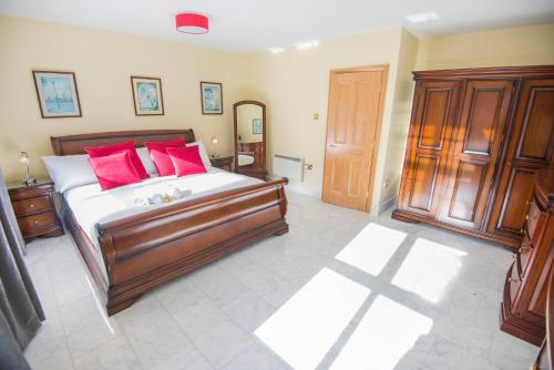 a bedroom with a large bed with red pillows at The Sir John Rodgersons Suite in Dublin