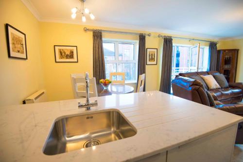 a kitchen with a sink and a living room at The Sir John Rodgersons Suite in Dublin