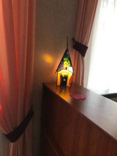 a lamp sitting on top of a dresser next to a window at Centralnyi hotel in Poltava